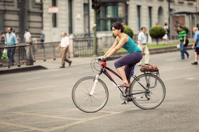 Ciclista por calle Alcalá, Madrid y peatones por detrás